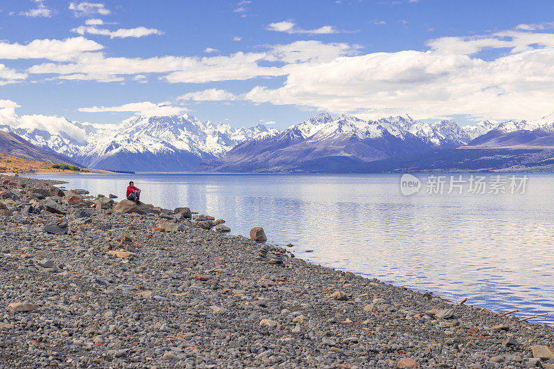 一位旅人在新西兰普卡基湖上享受宁静的风景