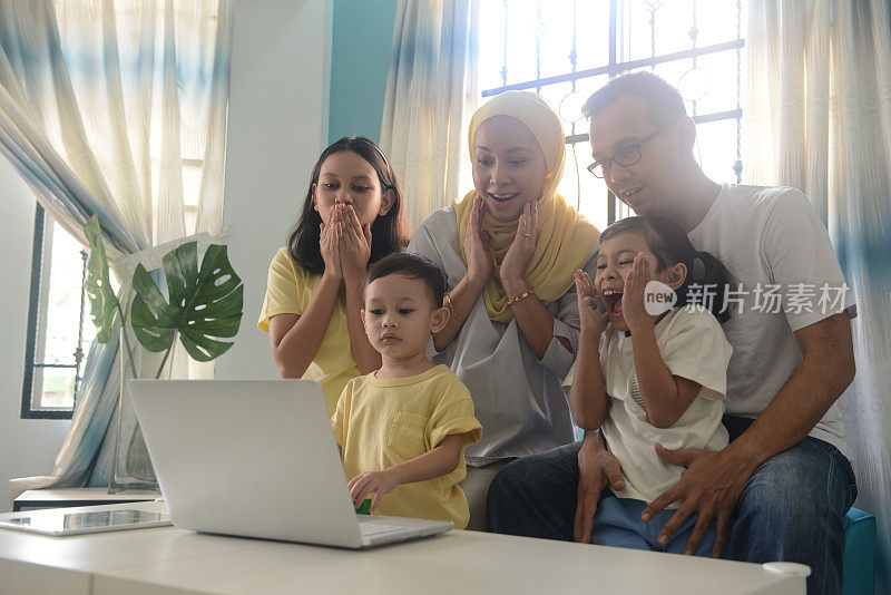 一个马来西亚家庭在家里一起使用笔记本电脑