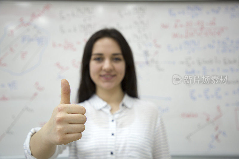 女同学在黑板前写公式