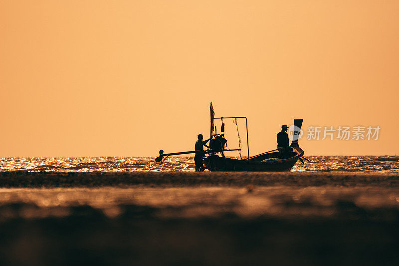 泰国海岸线有渔船。日落