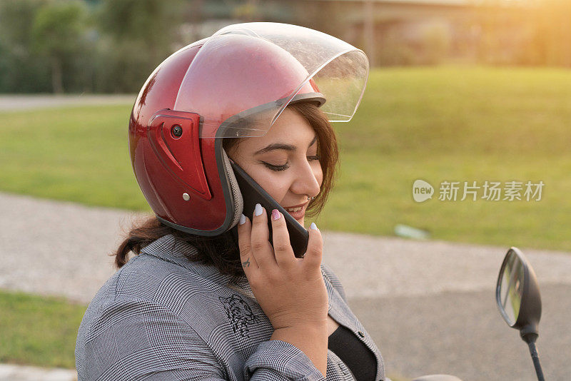 年轻女子在摩托车上打电话