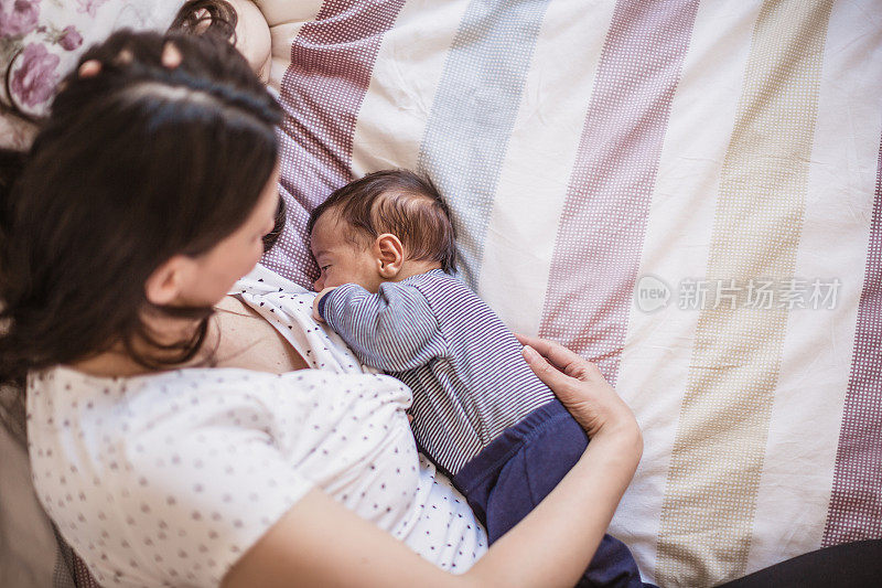 年轻的母亲正在母乳喂养她的男婴