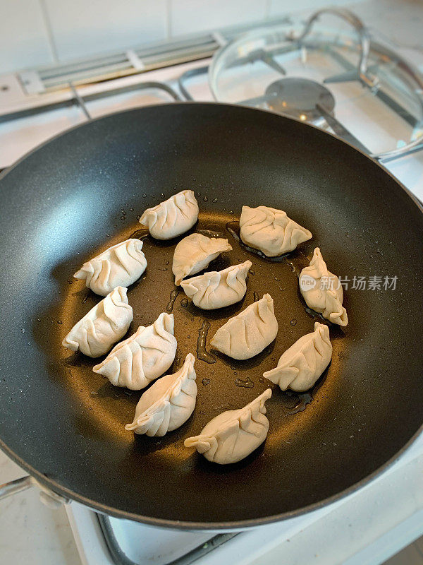 在煎锅里自制的饺子、饺子或中国饺子