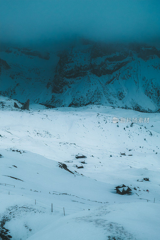 在意大利Dolomites，在蓝色的时间里，可以看到被雪覆盖的山和山上的小屋