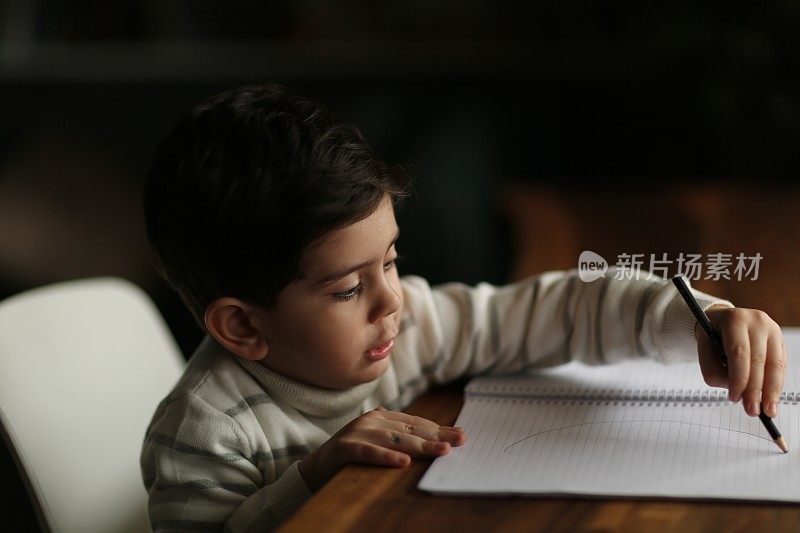 小男孩在空白纸上写字的肖像画