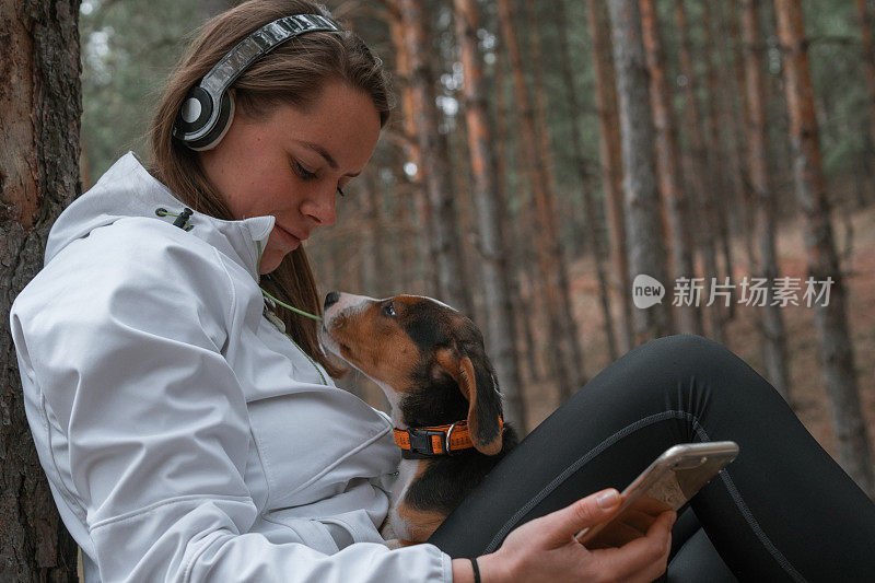 年轻的运动女性和她最好的朋友在大自然中放松