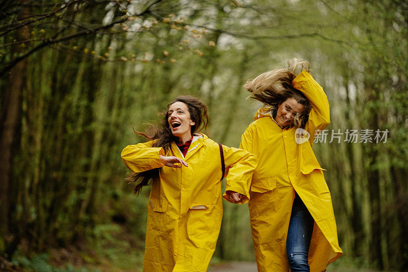 两个穿着黄色雨衣的年轻女子在雨中