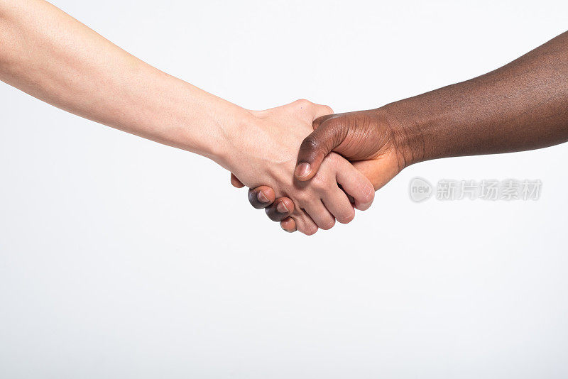 两种不同肤色的人握手的照片