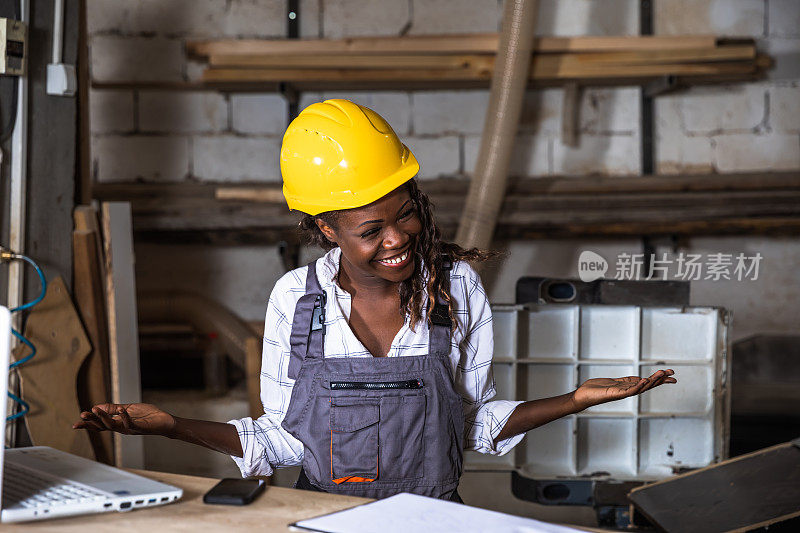 这是一位女木匠在她的工作室里使用笔记本电脑的照片