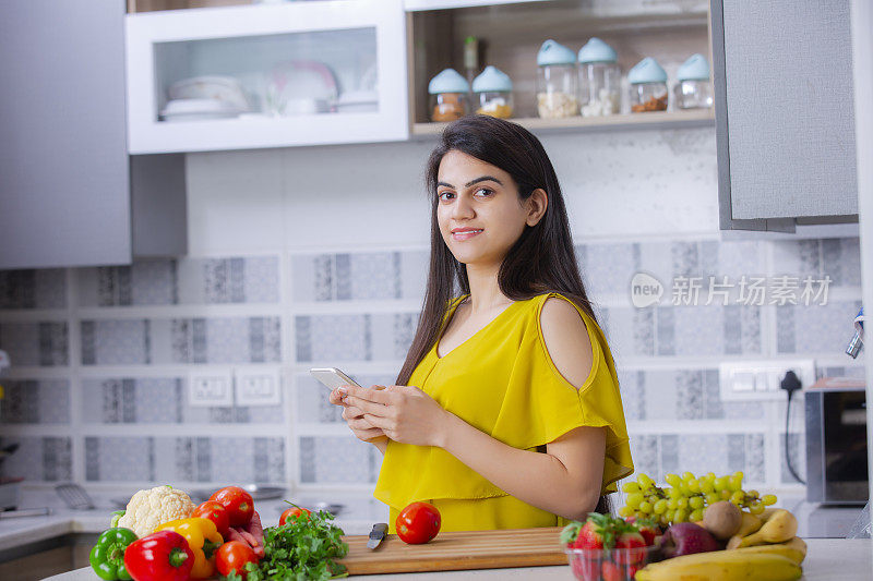年轻女子在厨房砧板上切水果