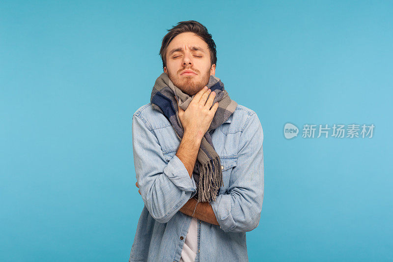 不健康的流感患者站在温暖的围巾中发抖，感觉不舒服