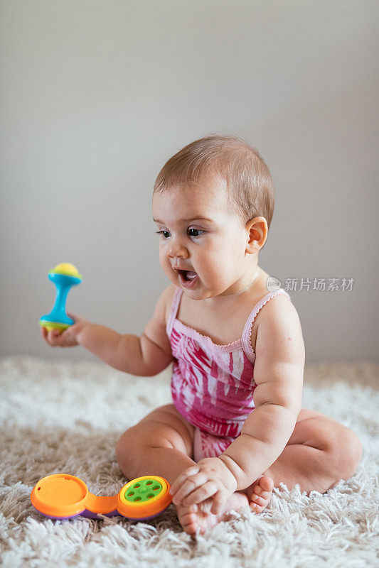6个月大的女婴在玩塑料玩具