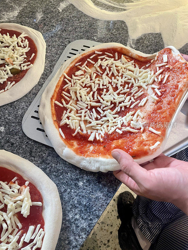 Pizzaiolo把披萨放在铲子上