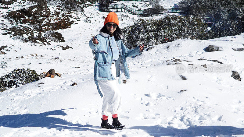 一个女人在寒冷的天气里穿行于白雪覆盖的山林之中