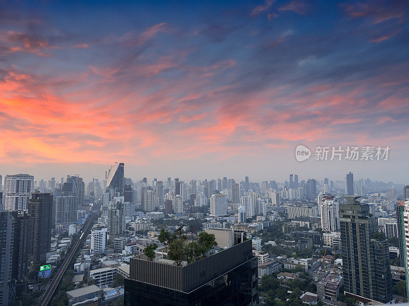 泰国曼谷市中心城市景观摩天楼天际线的特写图片，戏剧性，喜怒无常，大气，橙色和紫色的日落，多云的天空