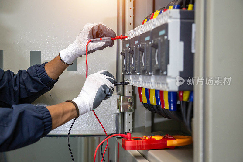 电工使用电表检查电气控制柜内的设备，确保设备和生命的安全。