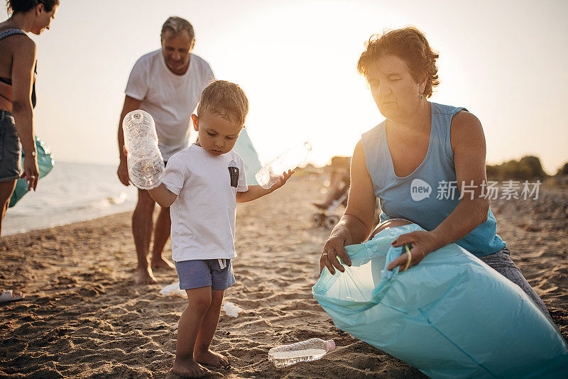 多代同堂——母亲，儿子，祖父和祖母，在海滩上捡垃圾