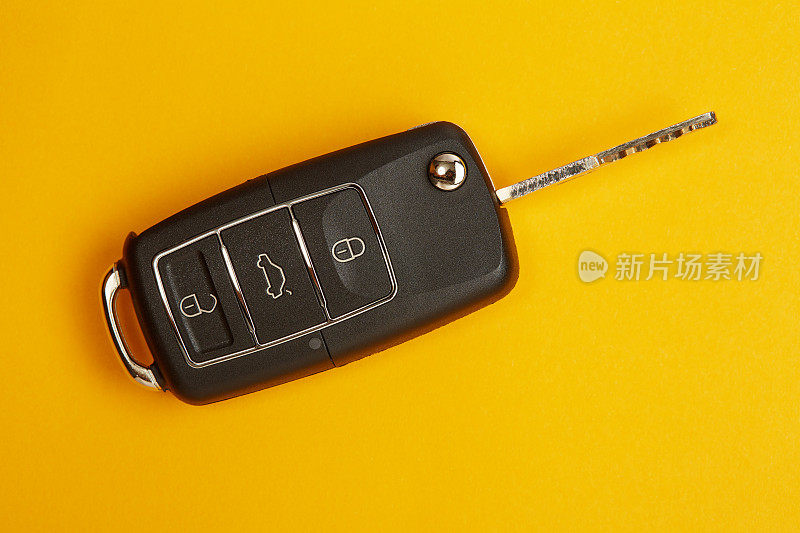 黄色背景的汽车钥匙，可遥控锁或开锁汽车和打开汽车后备箱
