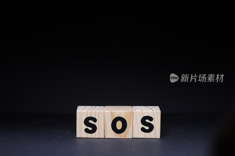 SOS字木制方块在黑色背景