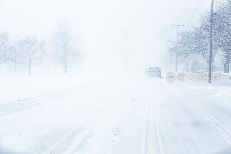 在眩目的暴风雪中几乎看不到前方的汽车