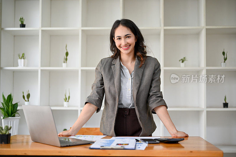 成功和自信的千禧一代亚洲女商人或女首席执行官在她的办公桌上。