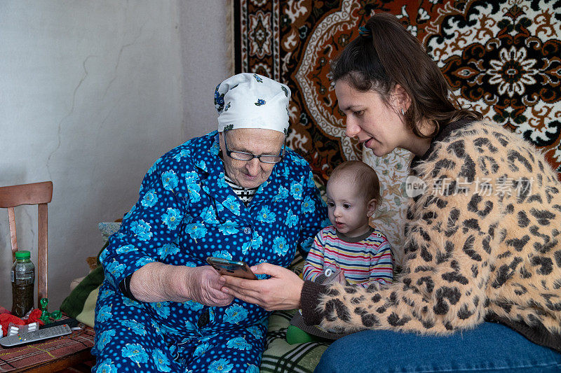 这位女士向她的祖母解释如何使用智能手机。