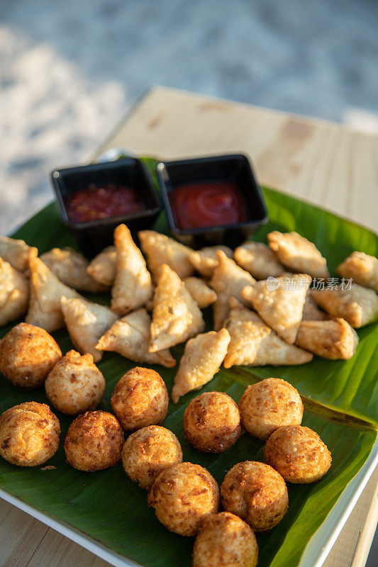 马尔代夫小吃，油炸手指食物，金枪鱼球，古拉和巴吉雅在海滩上的茶时间