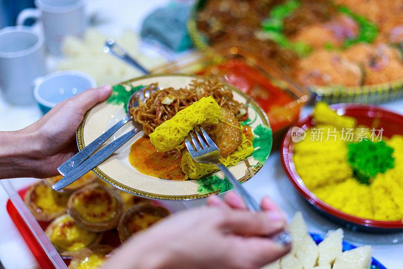 多元种族的马来西亚家庭在家里聚餐，吃各式各样的娘饭