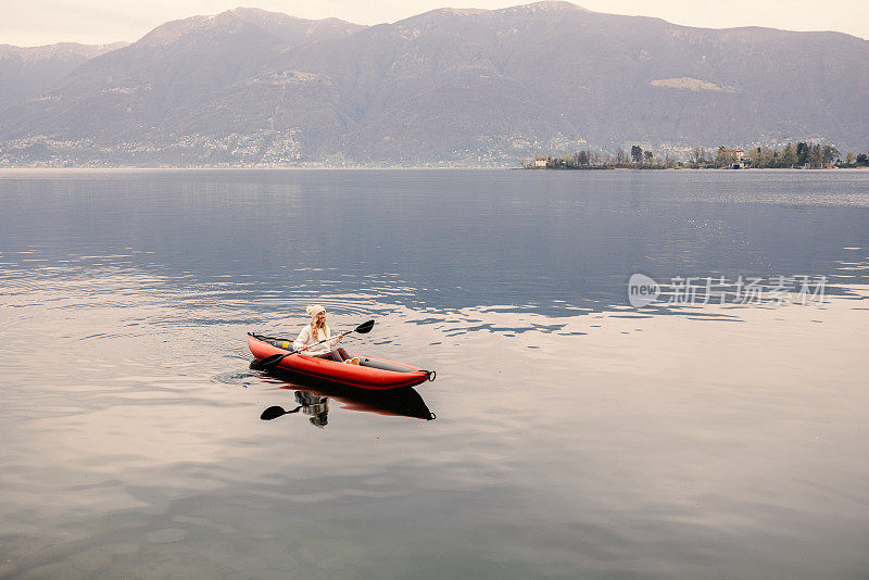 在平静的湖面上划独木舟的女人