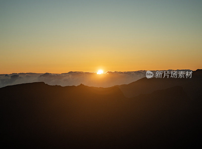 落日映衬下山峰的剪影