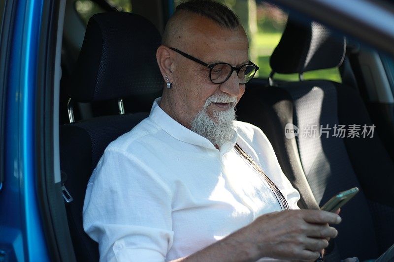 现代老年人在车里使用手机