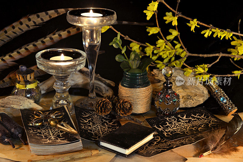 神秘的和神秘的静物与古老的魔法物品，塔罗牌，书和燃烧的蜡烛在女巫桌祭坛的神秘仪式和算命。万圣节和哥特式背景