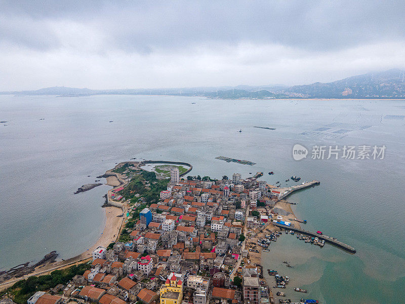 多云的天气，小岛和人口密集的房屋在海的中心