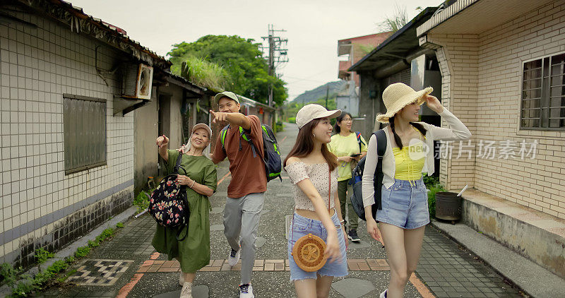 一群朋友走在传统的城镇街道上
