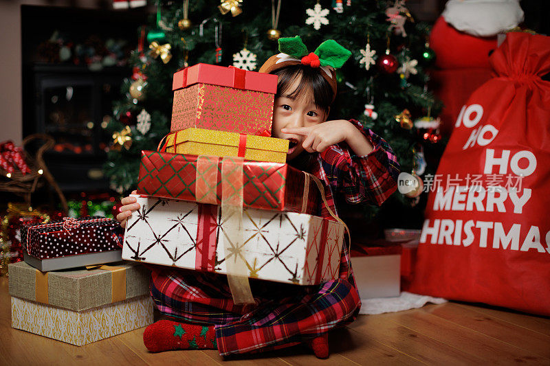 快乐的小女孩正在打开她的圣诞礼盒