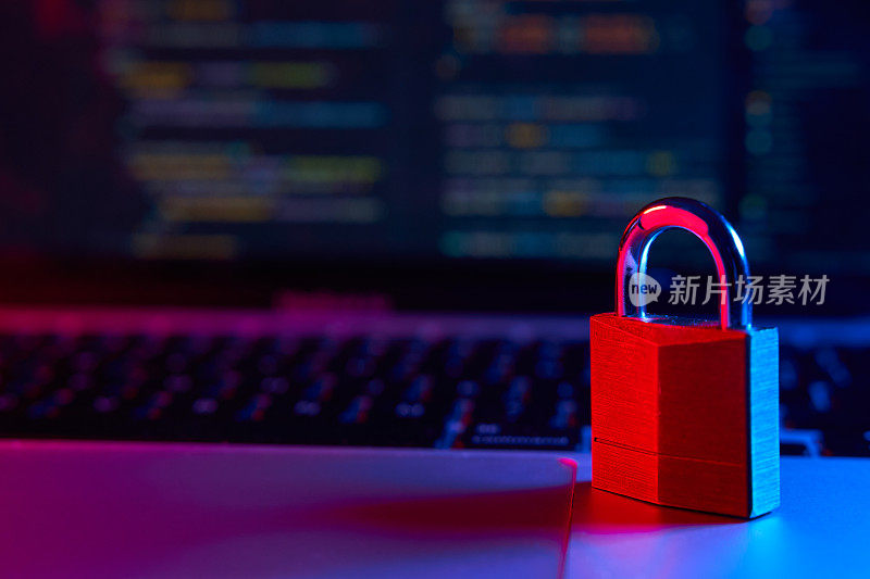 互联网安全理念。锁定笔记本电脑，背景中有蓝色和红色的灯光