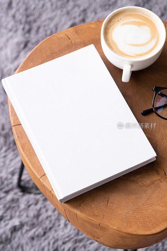 咖啡桌上的空白书模型，有装饰品和灰色地毯