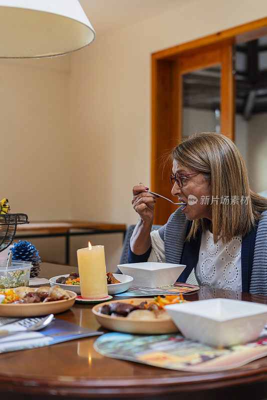 一位拉丁妇女在养老院里负责照顾她，吃着照顾她的人准备的美味午餐