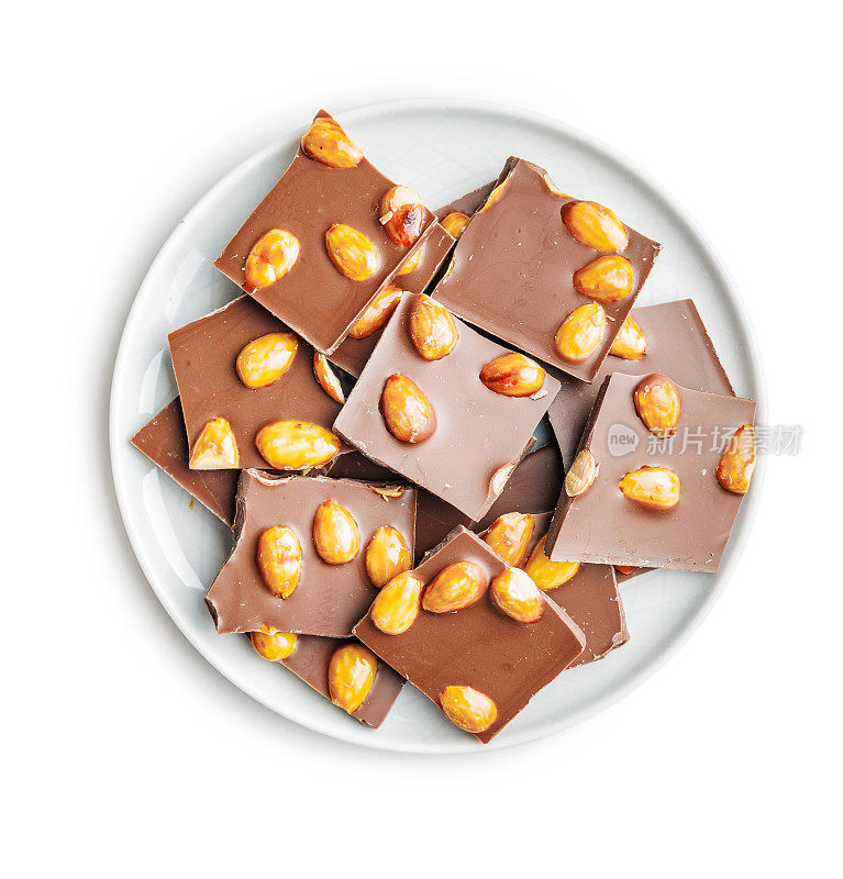 破碎的巧克力和杏仁放在盘子里，孤立在白色的背景上。
