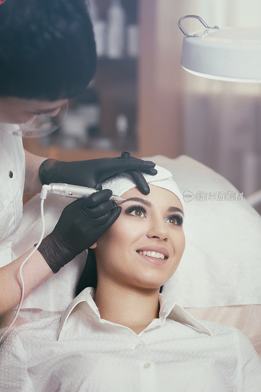 美容师在眉毛纹身上做永久性的化妆