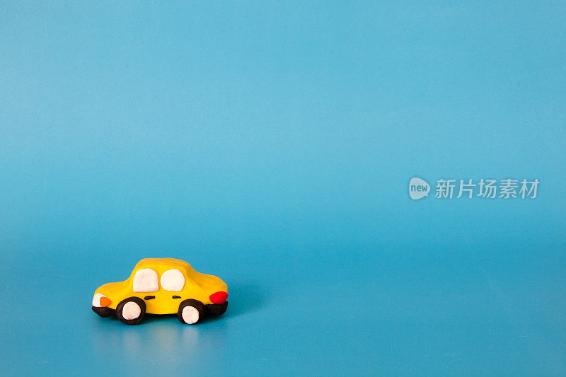 黄色的汽车模型粘土在蓝色的背景