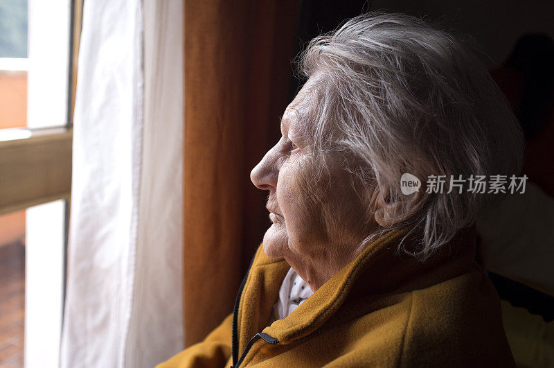 一个老妇人在看窗户