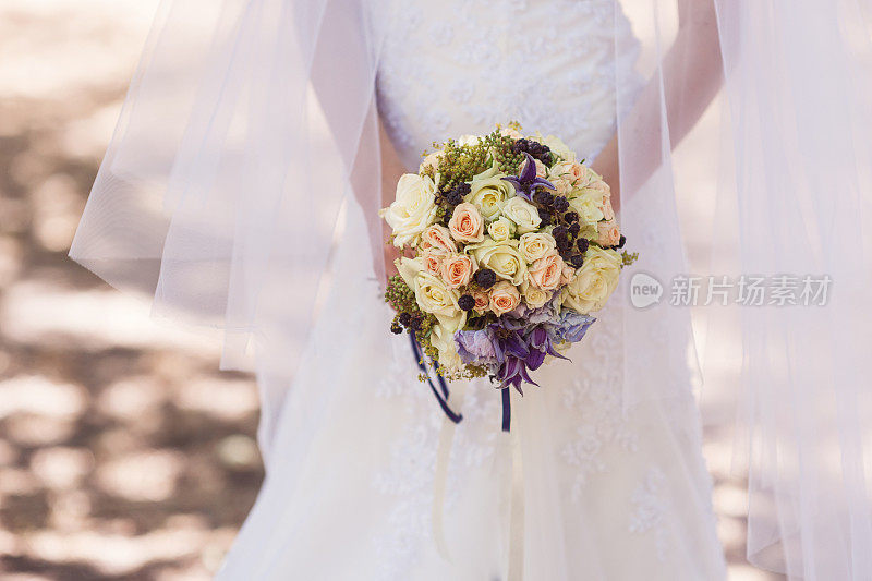 新娘手持一束漂亮的新娘花束走在路上