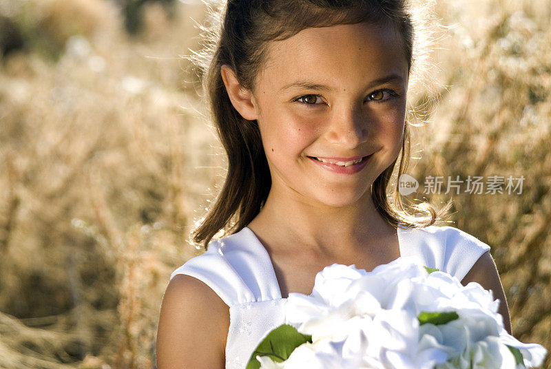 花童在田野里捧着一束白花