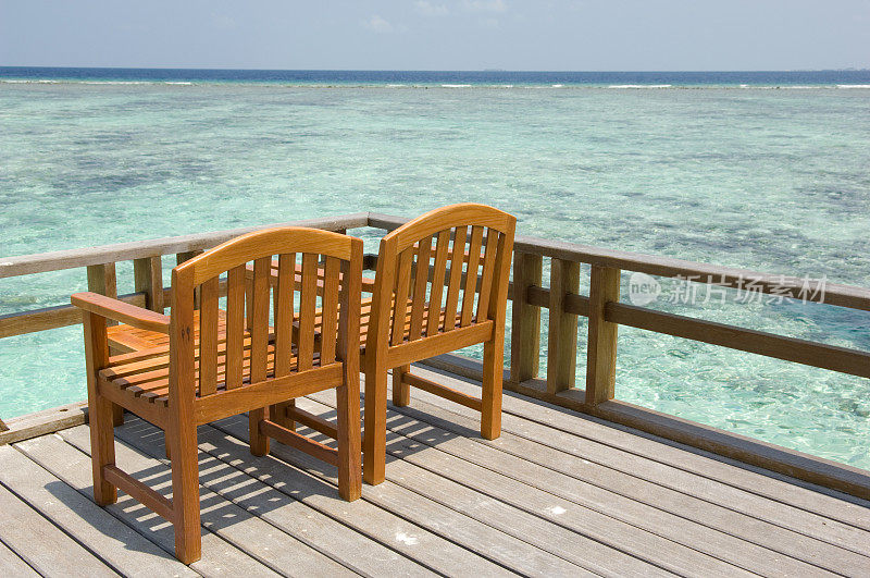 椅子在海滩附近的甲板上