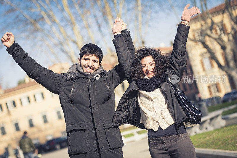 一对幸福的夫妇在街上举起手