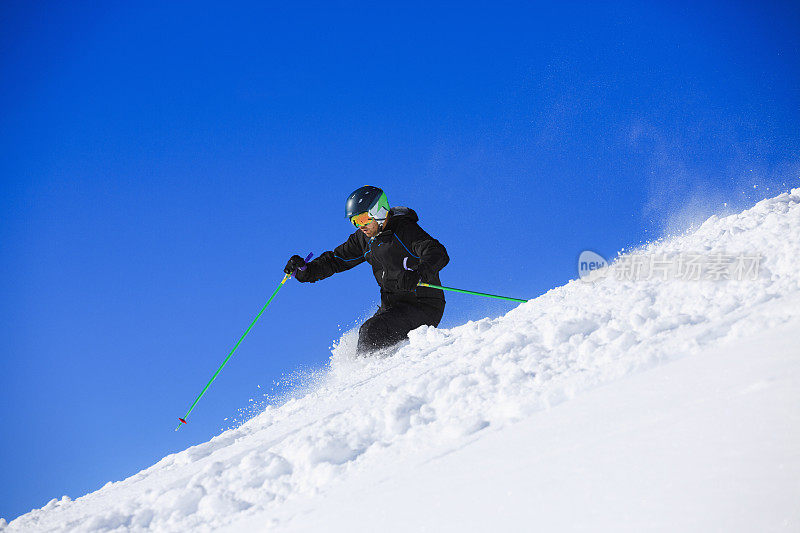 成熟的男人离开雪道，在阳光明媚的滑雪场滑雪