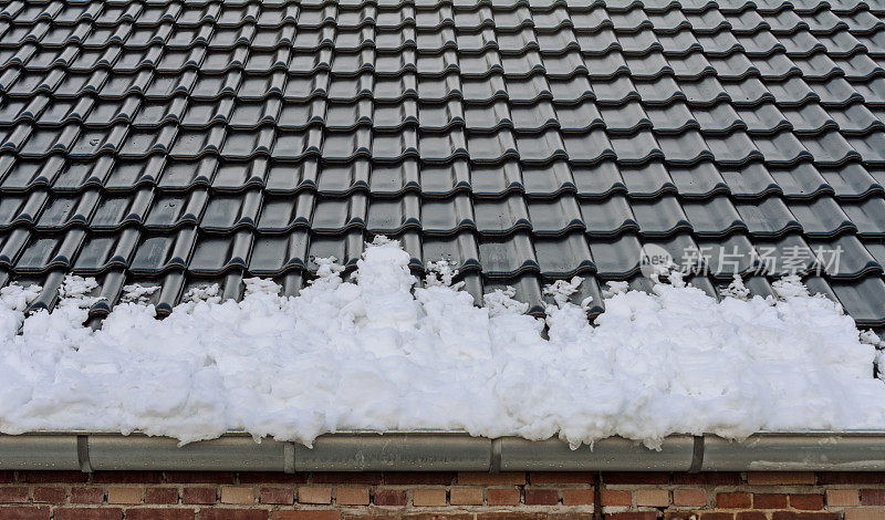 满是积雪的水沟从屋顶滑落下来