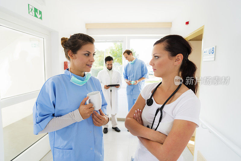 女医生和护士在医院走廊里交谈