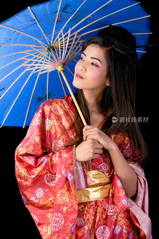 美丽的艺妓看着别处，带着蓝色的阳伞。